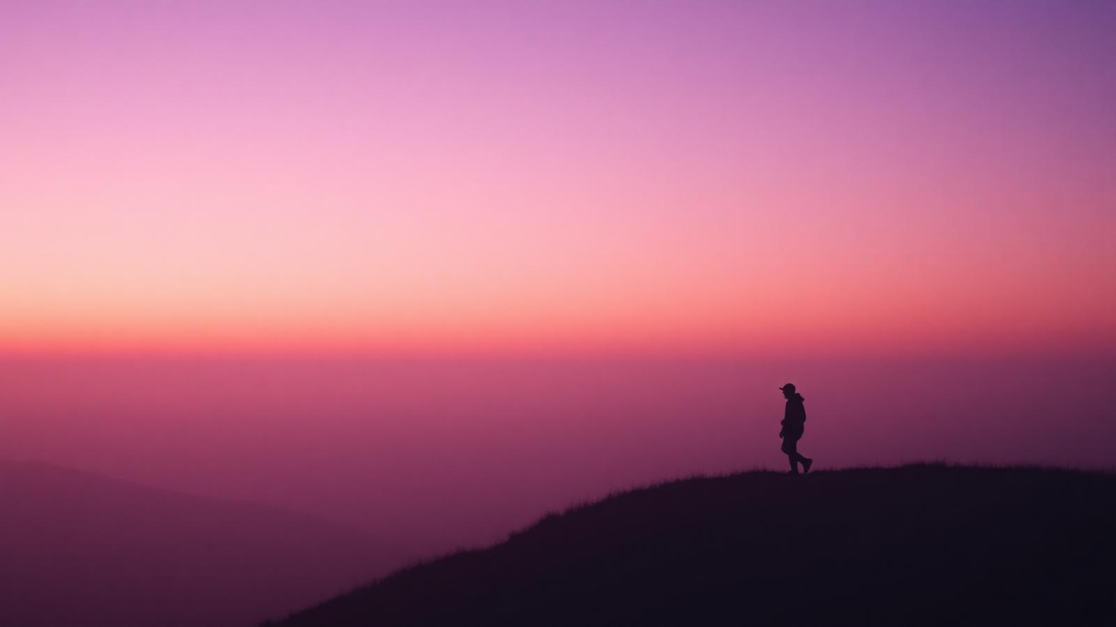 Solitary silhouette on a lilac ridge at dawn
